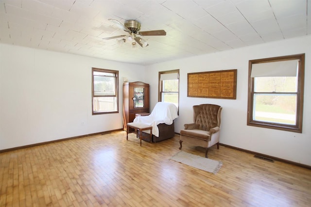 W1796 Puddlefort St, Mount Calvary, WI 53057 - living area featuring a ceiling fan, light wood finished floors, and baseboards