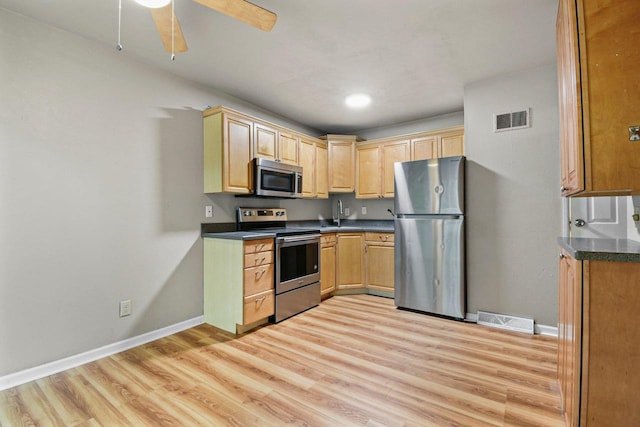 227 E Bluff, Madison, WI 53704 - kitchen featuring appliances with stainless steel finishes, light brown cabinetry, light wood-style flooring, dark countertops, and a ceiling fan