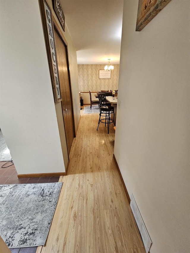 400 Old Indian Trl, Deforest, WI 53532 - hall featuring wallpapered walls, baseboards, wood finished floors, and a chandelier