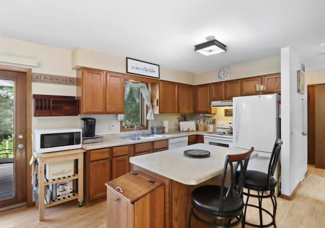 400 Old Indian Trl, Deforest, WI 53532 - kitchen featuring white appliances, light wood-style floors, a sink, a center island, and light countertops