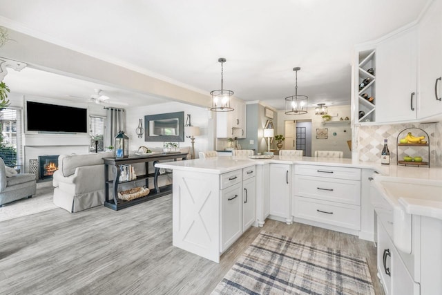18 Abbey Villas Cir Unit G, Fontana, WI 53125 - kitchen with open floor plan, a peninsula, white cabinets, light countertops, and ornamental molding