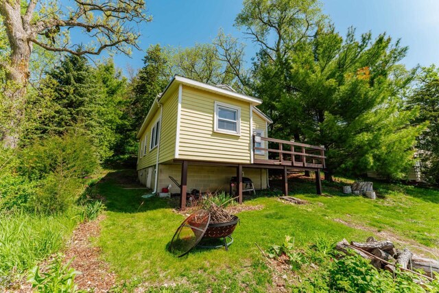 W6641 N Lakeshore Dr, Elkhorn, WI 53121 - back of house featuring a wooden deck, a yard, and an outdoor fire pit