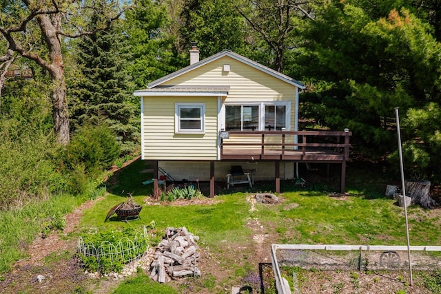 W6641 N Lakeshore Dr, Elkhorn, WI 53121 - rear view of house featuring an outdoor fire pit, a wooden deck, a lawn, and a chimney