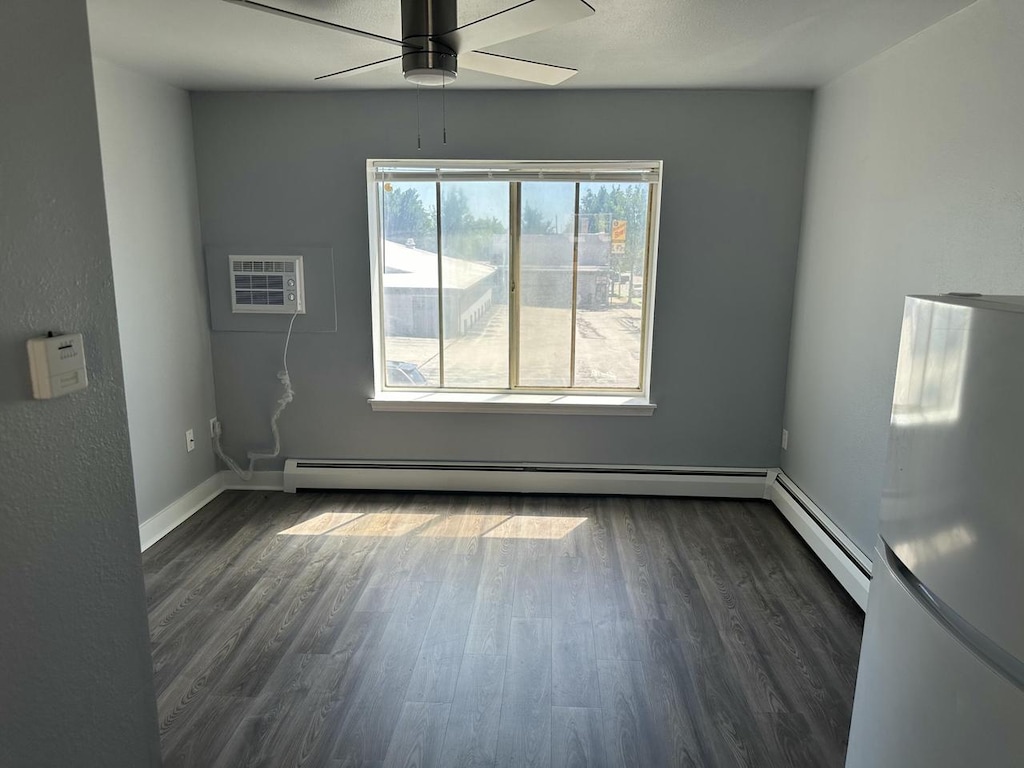 6100 W Burnham St, West Allis, WI 53219 - spare room with a baseboard radiator, a ceiling fan, dark wood-style flooring, a baseboard heating unit, and baseboards