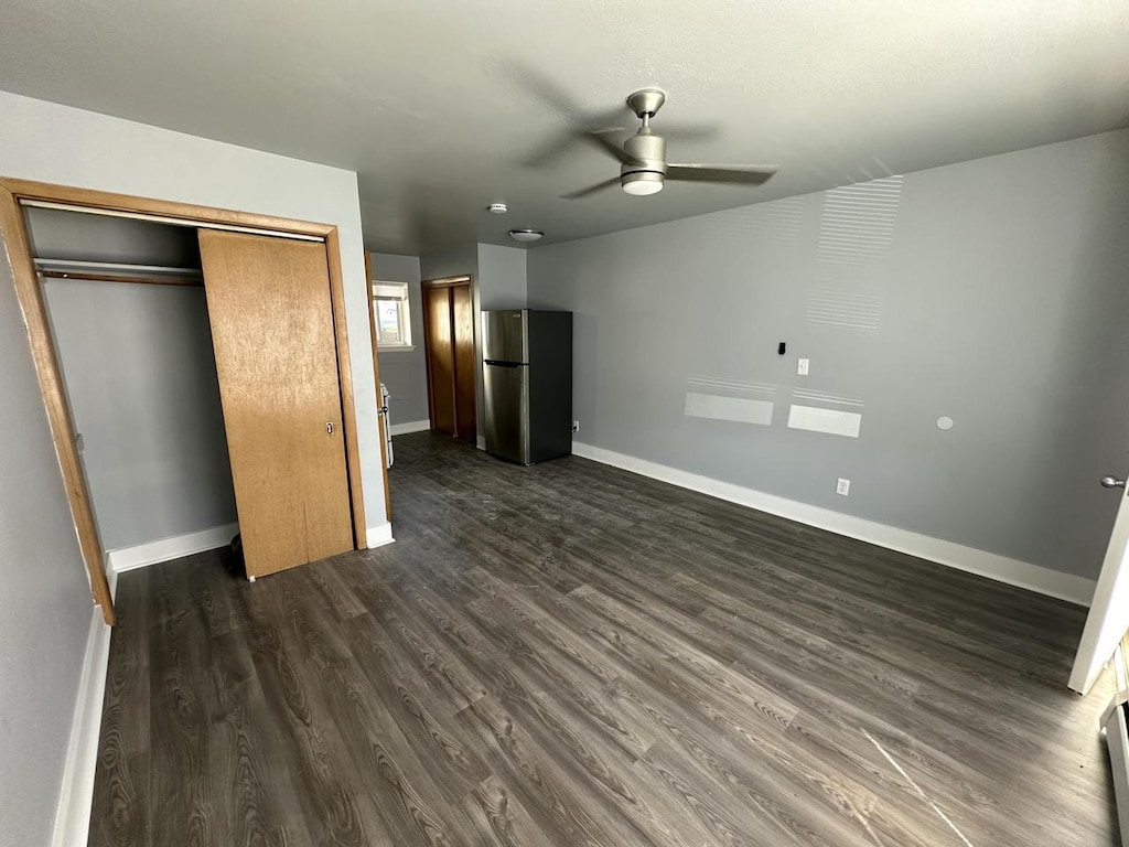 6100 W Burnham St, West Allis, WI 53219 - unfurnished bedroom with freestanding refrigerator, dark wood-style floors, baseboards, and a closet