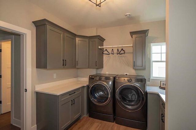 W214N6684 Fairview Dr, Menomonee Falls, WI 53051 - laundry room featuring independent washer and dryer, cabinet space, and wood finished floors