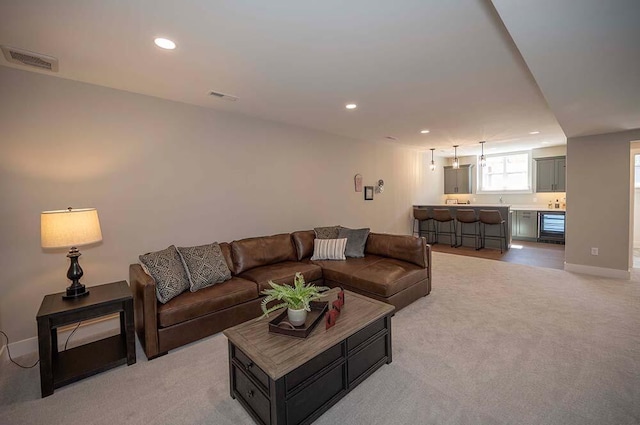W214N6684 Fairview Dr, Menomonee Falls, WI 53051 - living area with recessed lighting, light colored carpet, bar with sink, beverage cooler, and baseboards