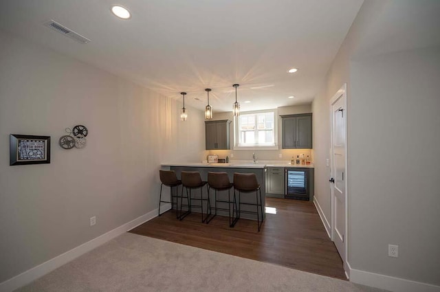 W214N6684 Fairview Dr, Menomonee Falls, WI 53051 - kitchen with wine cooler, a breakfast bar, a peninsula, baseboards, and light countertops