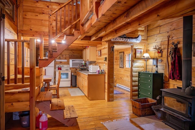 N8378 Timber Trl, New Lisbon, WI 53950 - kitchen with white range with electric cooktop, a wood stove, wooden walls, and light wood-style flooring