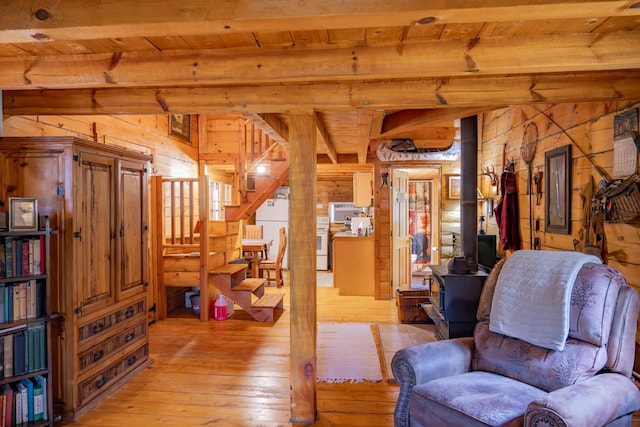 N8378 Timber Trl, New Lisbon, WI 53950 - living area featuring wooden ceiling with exposed beams, wood walls, light wood-style floors, stairs, and a wood stove