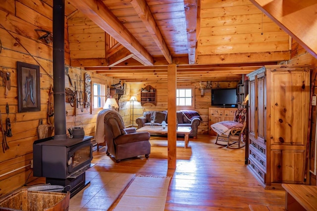N8378 Timber Trl, New Lisbon, WI 53950 - living room featuring wooden walls, a wood stove, wood ceiling with exposed beams, and hardwood / wood-style flooring