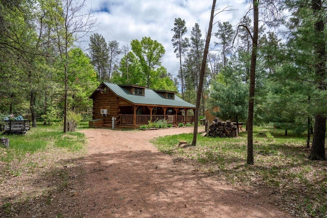 N8378 Timber Trl, New Lisbon, WI 53950 - log-style house with driveway, covered porch, and metal roof