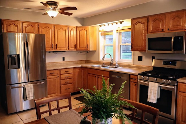 811 Spruce Dr, La Crescent, MN 55947 - kitchen featuring stainless steel appliances, a sink, light countertops, light tile patterned floors, and a ceiling fan