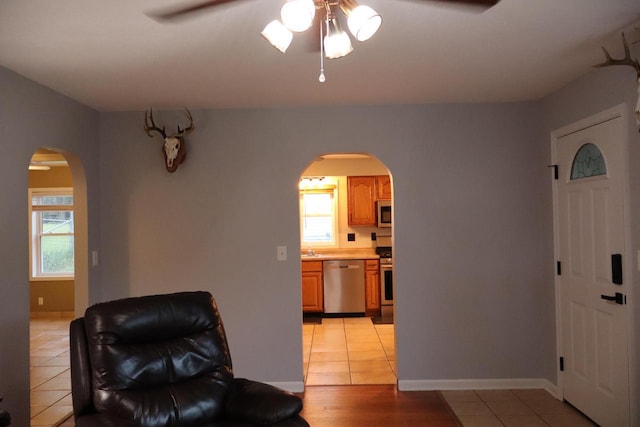 811 Spruce Dr, La Crescent, MN 55947 - living area featuring arched walkways, a ceiling fan, light tile patterned flooring, and healthy amount of natural light
