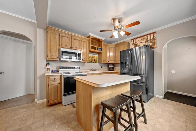 1215 Hastings St, Green Bay, WI 54301 - kitchen with stainless steel appliances, arched walkways, light countertops, a sink, and crown molding