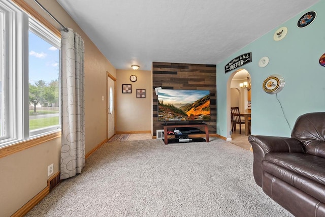 1215 Hastings St, Green Bay, WI 54301 - living area featuring an accent wall, arched walkways, healthy amount of natural light, and light colored carpet