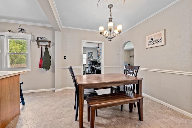 1215 Hastings St, Green Bay, WI 54301 - dining room featuring arched walkways, crown molding, a chandelier, and baseboards
