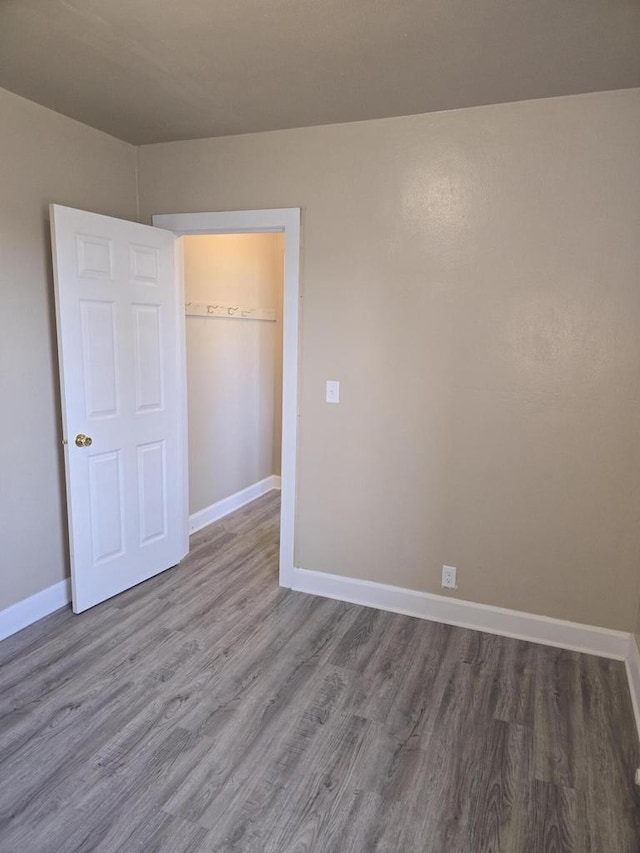 945 N Memorial Dr, Racine, WI 53404 - unfurnished bedroom with wood finished floors, baseboards, and a closet