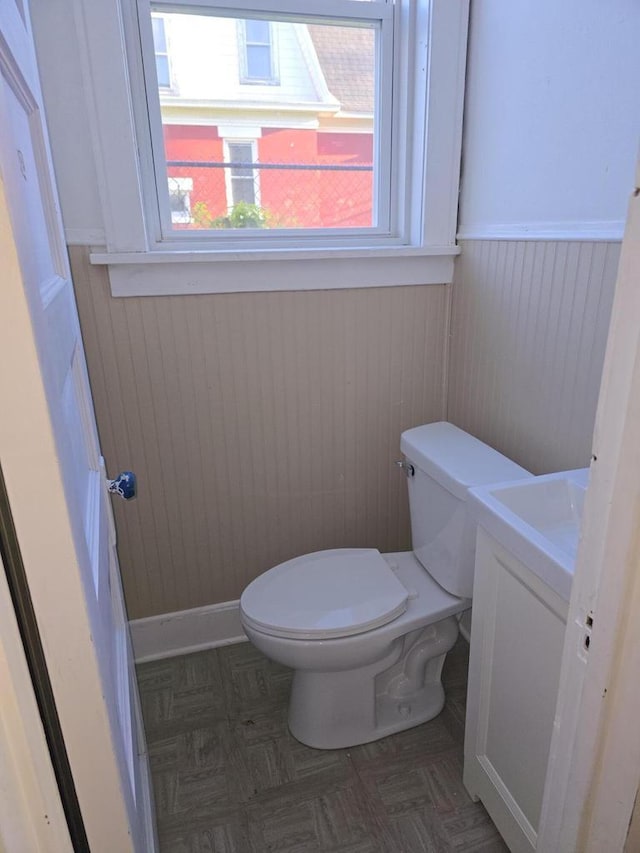 945 N Memorial Dr, Racine, WI 53404 - bathroom featuring toilet, a wainscoted wall, vanity, and wood walls