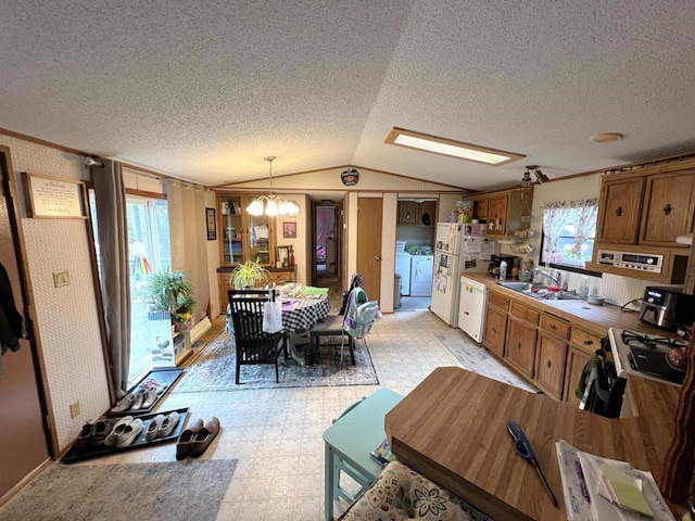 6898 Barbara Dr, Lake Tomahawk, WI 54539 - kitchen with white appliances, lofted ceiling, a sink, light flooring, and washer and dryer