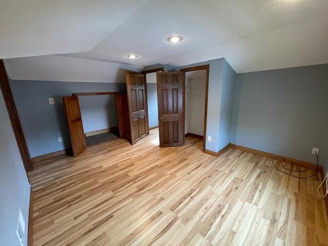 120 Hudson St, Antigo, WI 54409 - additional living space with vaulted ceiling, light wood-style floors, and baseboards