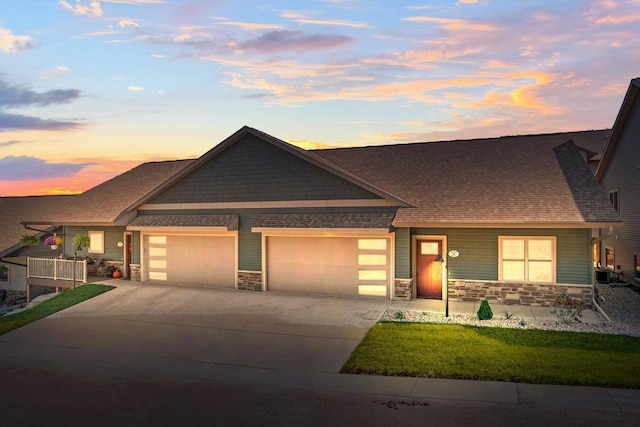 28 Sienna Hills Cir, Mount Horeb, WI 53572 - view of front of house with stone siding, a garage, concrete driveway, a front yard, and a shingled roof