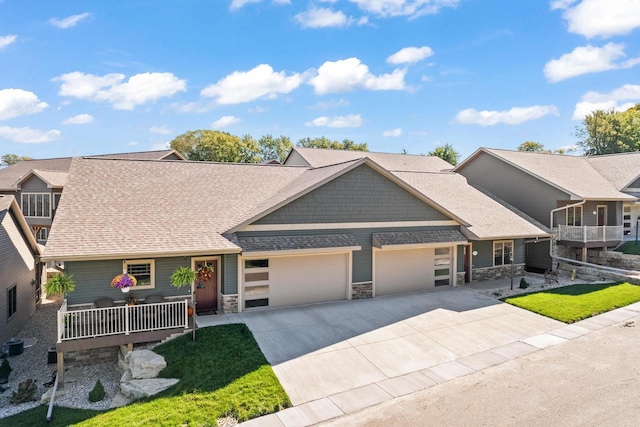 28 Sienna Hills Cir, Mount Horeb, WI 53572 - view of front of property with an attached garage, stone siding, concrete driveway, and roof with shingles