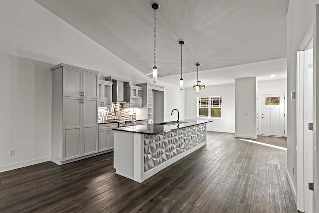 28 Sienna Hills Cir, Mount Horeb, WI 53572 - kitchen featuring a sink, dark wood-type flooring, a center island with sink, dark countertops, and wall chimney exhaust hood