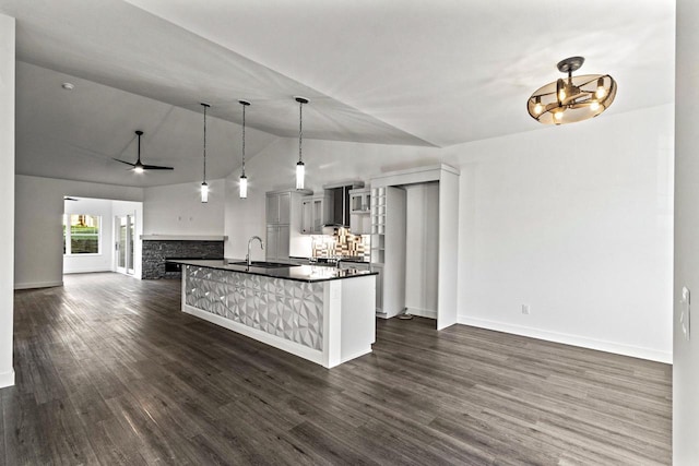 28 Sienna Hills Cir, Mount Horeb, WI 53572 - kitchen featuring dark countertops, a sink, open floor plan, vaulted ceiling, and baseboards