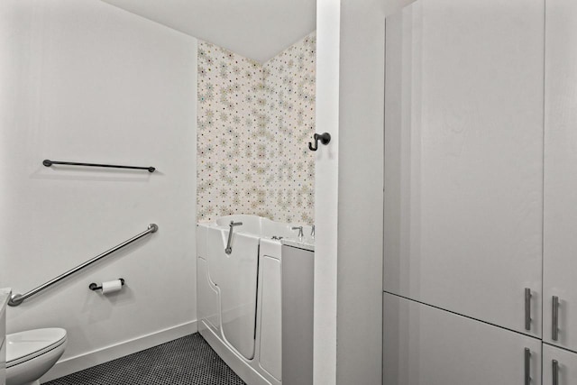 28 Sienna Hills Cir, Mount Horeb, WI 53572 - bathroom with toilet, a garden tub, tile patterned flooring, and baseboards