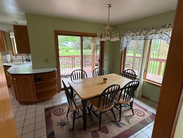 3108 Hawks Haven Trl, Deforest, WI 53532 - dining space with light tile patterned flooring, a chandelier, and healthy amount of natural light