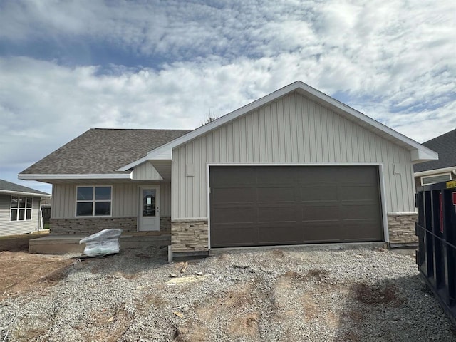 710 Tambour Ct, De Pere, WI 54115 - view of front of home featuring dirt driveway, roof with shingles, board and batten siding, and stone siding