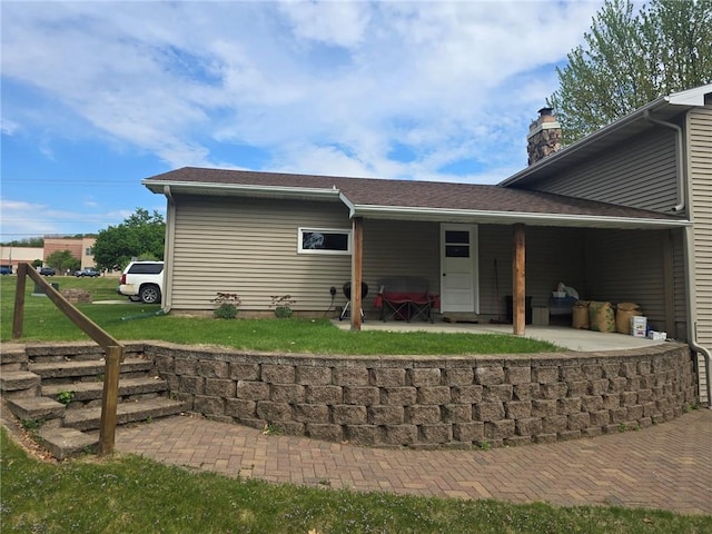 2626 Abbe Hill Dr, Eau Claire, WI 54703 - rear view of house with a patio, a chimney, and a yard