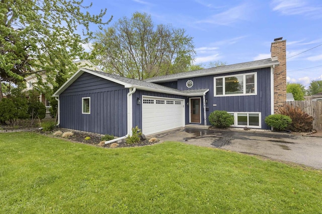 2104 Hazel St, Oshkosh, WI 54901 - view of front of property featuring asphalt driveway, a garage, and a chimney
