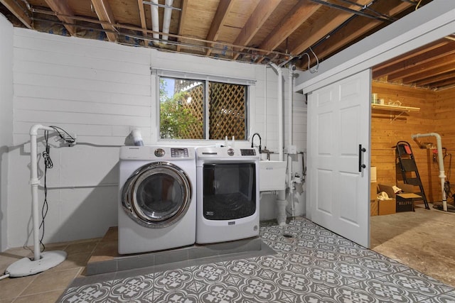 2104 Hazel St, Oshkosh, WI 54901 - washroom featuring separate washer and dryer, wooden walls, tile patterned flooring, and a sink