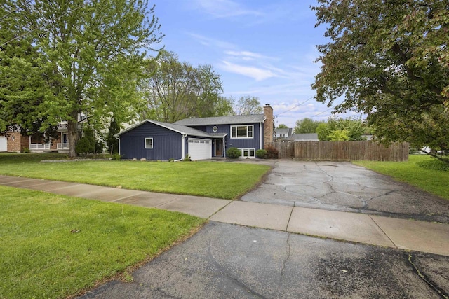 2104 Hazel St, Oshkosh, WI 54901 - view of front facade featuring asphalt driveway, a chimney, and a garage