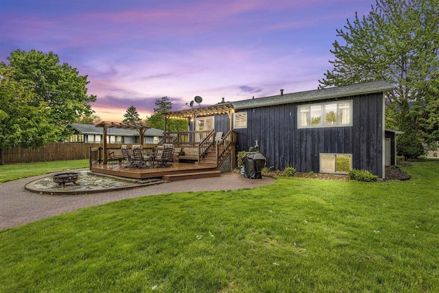 2104 Hazel St, Oshkosh, WI 54901 - back of property at dusk featuring a fire pit, a deck, a pergola, and a patio