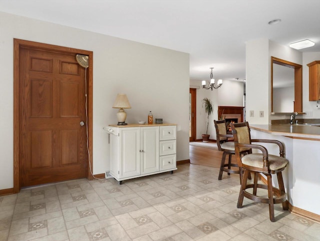 W11065 Menominee Rd, Portage, WI 53901 - kitchen with baseboards, a chandelier, and a kitchen breakfast bar