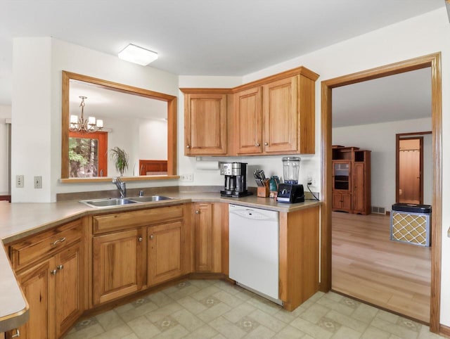 W11065 Menominee Rd, Portage, WI 53901 - kitchen featuring white dishwasher, a sink, a chandelier, brown cabinetry, and light floors