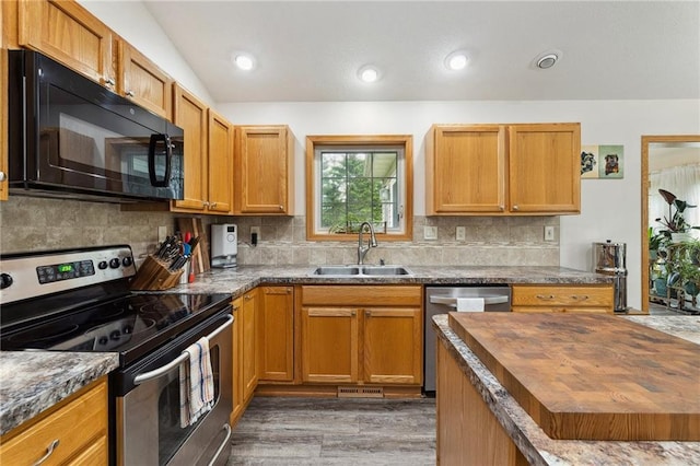 819 Fairway Cir, Black River Falls, WI 54615 - kitchen featuring stainless steel appliances, a sink, wooden counters, decorative backsplash, and light wood-style flooring