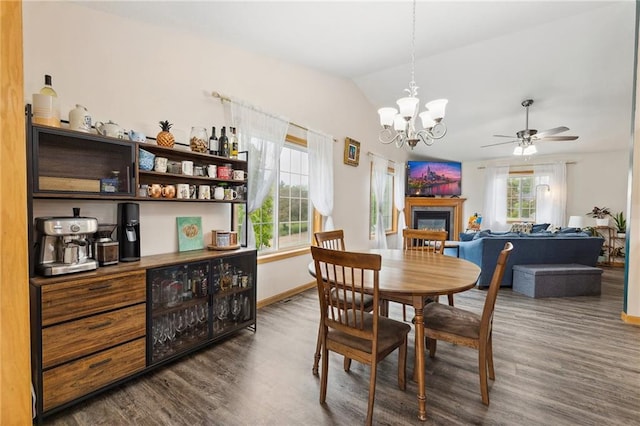 819 Fairway Cir, Black River Falls, WI 54615 - dining area with dark wood-style floors, baseboards, lofted ceiling, a ceiling fan, and a glass covered fireplace