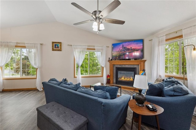 819 Fairway Cir, Black River Falls, WI 54615 - living area with wood finished floors, vaulted ceiling, a glass covered fireplace, ceiling fan, and baseboards