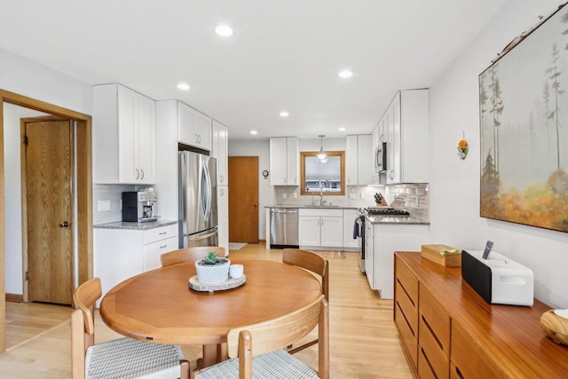4912 Schofield St, Monona, WI 53716 - kitchen featuring stainless steel appliances, a sink, light wood-style floors, backsplash, and recessed lighting