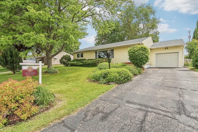 4912 Schofield St, Monona, WI 53716 - ranch-style house featuring a front yard, asphalt driveway, and a garage