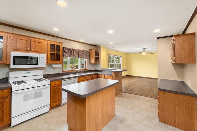 11253 State Highway 71, Sparta, WI 54656 - kitchen with white appliances, ornamental molding, light floors, dark countertops, and brown cabinetry