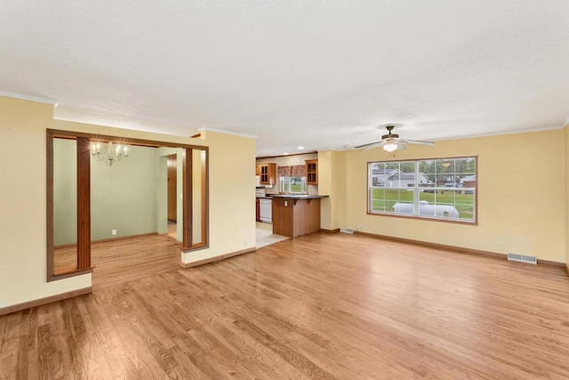 11253 State Highway 71, Sparta, WI 54656 - unfurnished living room featuring light wood-style floors, ornamental molding, a chandelier, baseboards, and a ceiling fan