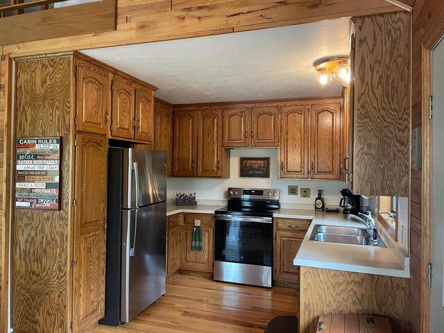 17235 Little Archibald Rd, Townsend, WI 54175 - kitchen with appliances with stainless steel finishes, light wood-style floors, brown cabinets, and a sink
