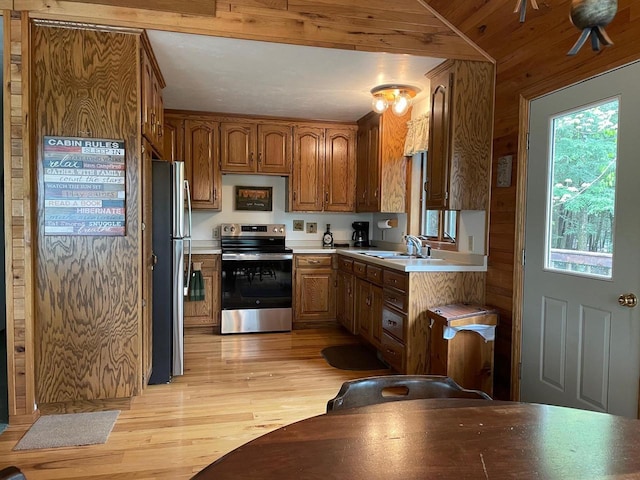 17235 Little Archibald Rd, Townsend, WI 54175 - kitchen featuring appliances with stainless steel finishes, a sink, light wood-style flooring, light countertops, and brown cabinets