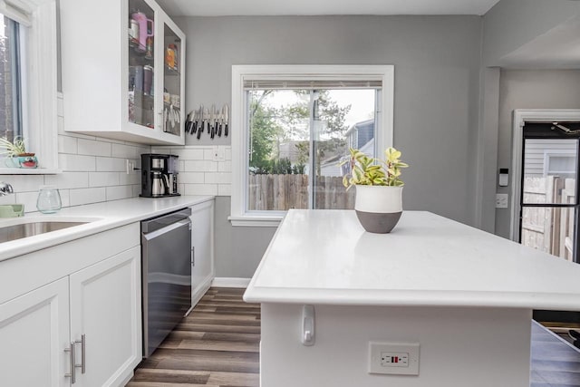 4892 N Mohawk Ave, Glendale, WI 53217 - kitchen with stainless steel dishwasher, a sink, light countertops, white cabinets, and glass insert cabinets