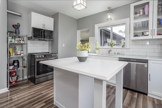 4892 N Mohawk Ave, Glendale, WI 53217 - kitchen featuring appliances with stainless steel finishes, light countertops, a sink, dark wood finished floors, and tasteful backsplash